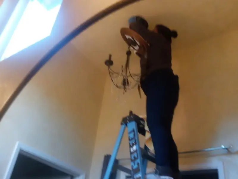 Electrician installing a chandelier in a Philadelphia residence